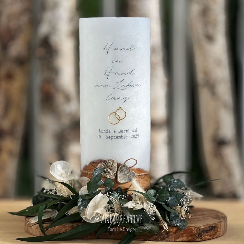 Hochzeitskerze mit Spruch „Hand in Hand ein Leben lang“, personalisiert mit Namen und Hochzeitsdatum, dekoriert mit stabilisiertem Blumenkranz und Olivenholz