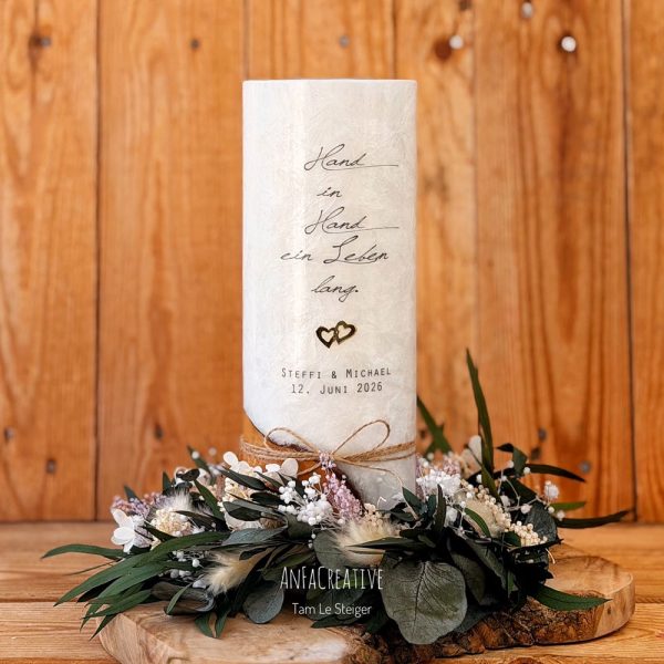 Moderne Hochzeitskerze mit Spruch, personalisierten Namen, goldenem Herzsymbol und Kranz aus stabilisierten Trockenblumen