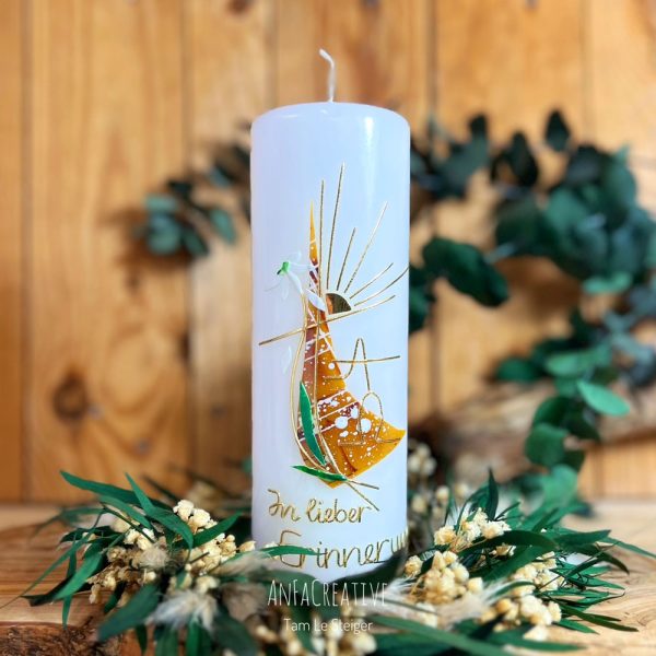 Weiße Gedenkkerze In lieber Erinnerung mit goldenem Schriftzug auf Holztisch.